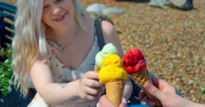 kuvituskuva, kolme eriväristä jäätelöä henkilöiden käsissä